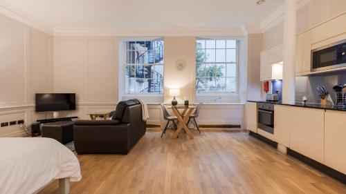 a room with a bed and a kitchen and a living room at Bank Serviced Apartments by LovelyStay in London