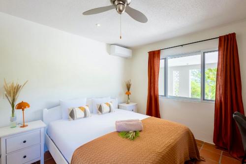 une chambre blanche avec un lit et une fenêtre dans l'établissement Coral Estate Rentals, à Willibrordus