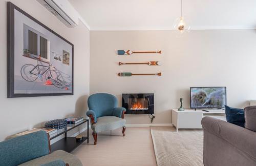 a living room with a couch and a fireplace at OrangeTreeHouses in Montijo