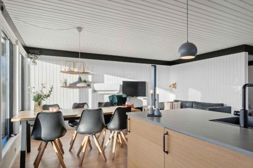 a kitchen and dining room with a table and chairs at Cozy Summer House Close To Beach And Nature in Rønde