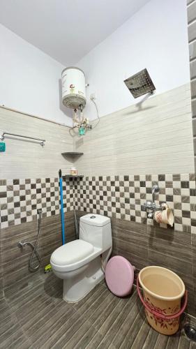 a bathroom with a toilet in a room at Khaleel Manzil Luxe Stays in Hyderabad