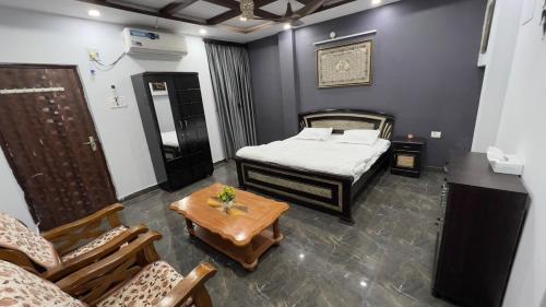 a bedroom with a bed and a table and chairs at Khaleel Manzil Luxe Stays in Hyderabad