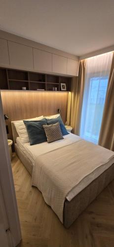 Un dormitorio con una cama grande con ventana. en Vilda Moderne, en Poznan