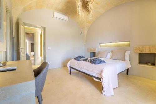 a bedroom with a bed and a table in a room at Villa del Cedro in Torre Vado