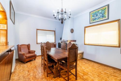 a dining room with a wooden table and chairs at Alojamento Garcia in Fânzeres