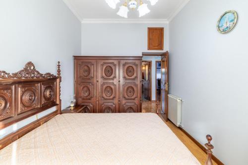 a bedroom with a large wooden bed in a room at Alojamento Garcia in Fânzeres