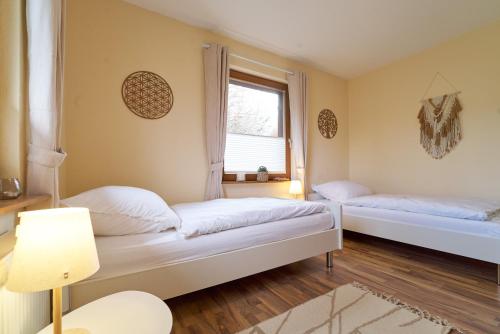 two beds in a room with a window at Ferienhaus am Spiegelberg in Lemgo in Lemgo