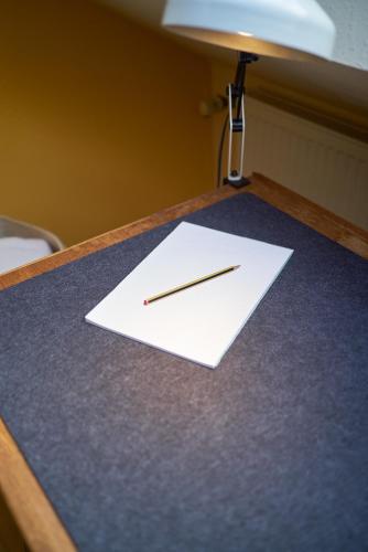 a pencil sitting on top of a piece of paper on a desk at Ferienhaus am Spiegelberg in Lemgo in Lemgo