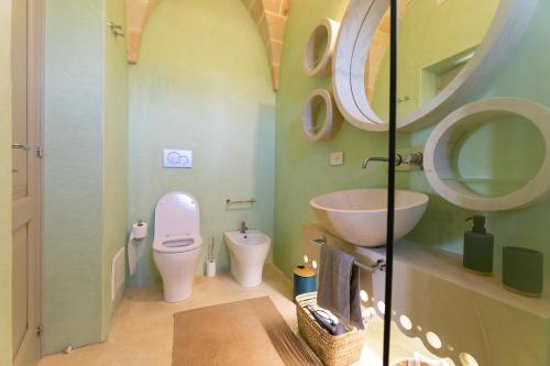 a bathroom with a toilet and a sink and a mirror at Villa del Cedro in Torre Vado