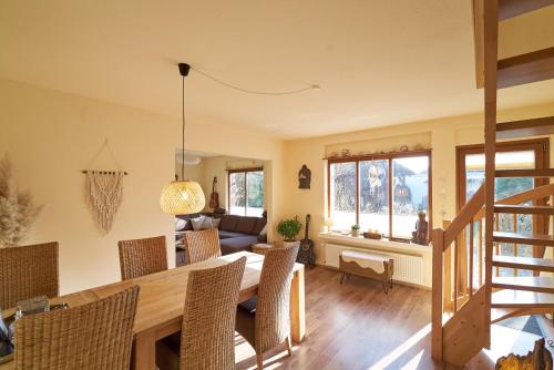 a dining room and living room with a table and chairs at Ferienhaus am Spiegelberg in Lemgo in Lemgo