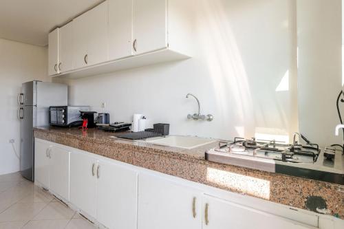 a white kitchen with a sink and a stove at Rabat Centro Apartments in Rabat