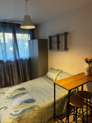 - une chambre avec un lit et une table avec des tabourets dans l'établissement Au bord de mer studio au calme à la ciotat, à La Ciotat
