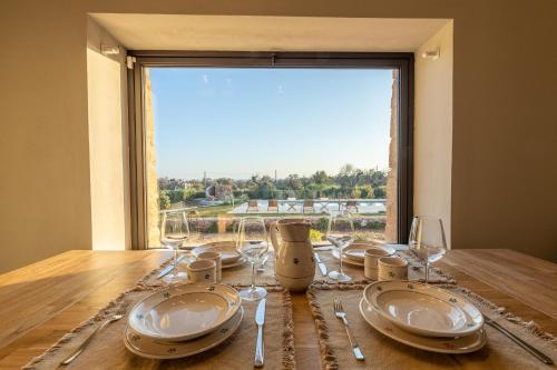 a table with plates and wine glasses and a window at Villa del Cedro in Torre Vado