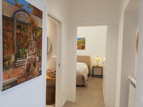a white hallway with a bedroom and a painting on the wall at Mondello Felix - appartamenti in villa a 600m dal mare in Mondello