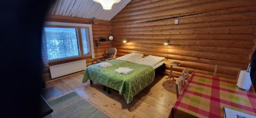 a bedroom with a bed in a log cabin at Ukonloma Aimola in Rovaniemi