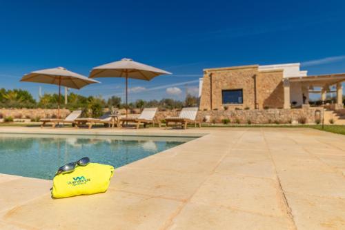 a yellow bag sitting next to a swimming pool at Villa del Cedro in Torre Vado