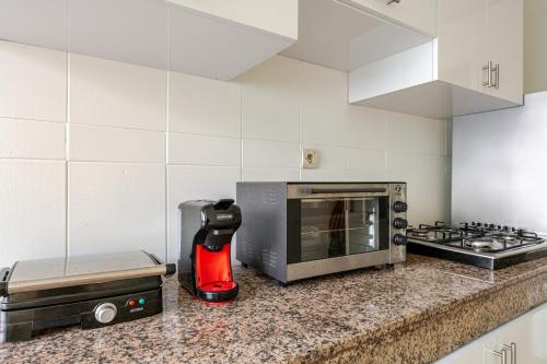 a kitchen counter with a microwave and a red appliance at Rabat Centro Apartments in Rabat