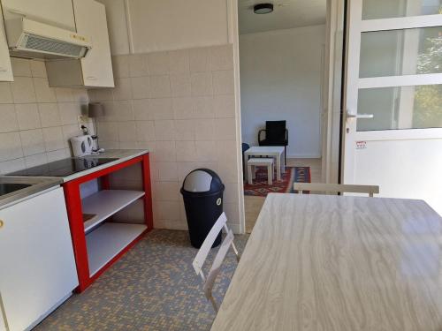 une cuisine avec une table et un comptoir rouge dans l'établissement Le Cocon de Cécile - Close to Paris-La Défense, à Bezons