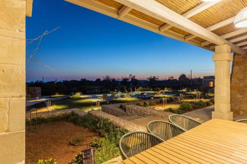 a patio with a table and chairs and a view of a park at Villa del Cedro in Torre Vado