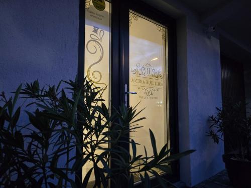 a door of a store with a plant in front of it at Boutique Arena in Piteşti