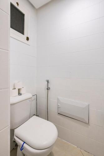 a white bathroom with a toilet and a sink at Rabat Centro Apartments in Rabat