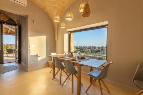 a dining room with a table and chairs and a large window at Villa del Cedro in Torre Vado