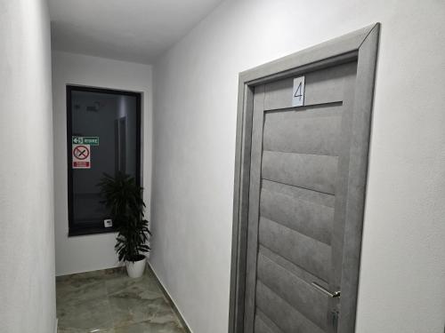 a door in a hallway with a potted plant at Boutique Arena in Piteşti