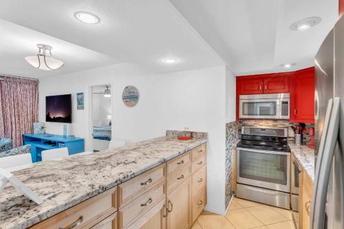 a kitchen with red cabinets and a counter top at First Floor Deluxe Condo -Updated and Chic in Naples