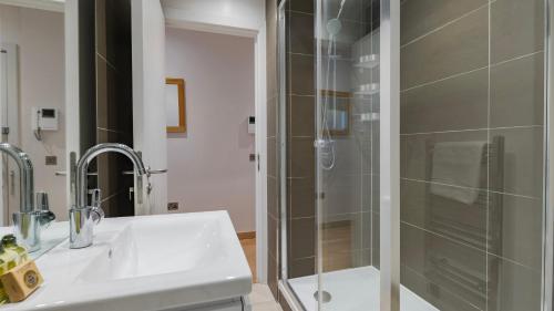 a bathroom with a shower and a white sink at Bank Serviced Apartments by LovelyStay in London