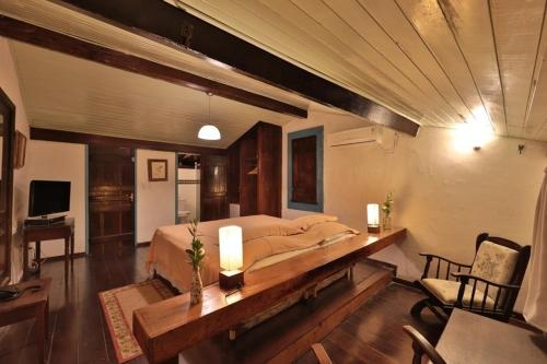 a bedroom with a large bed and a wooden table at Pousada do Amparo in Olinda