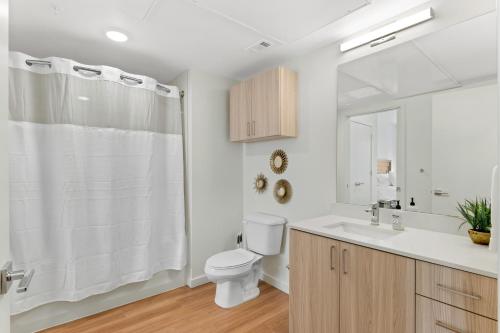 a white bathroom with a toilet and a sink at My Sweet Rentals- 30 night min in Aurora