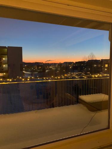 a window with a view of a city at night at Moderne leilighet, 3 sov, parkering. in Trondheim