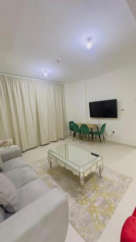 a living room with a couch and a table at Furnished room available for rent in new shahama for short stay in Abu Dhabi
