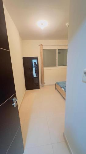 a room with a television and a room with a bed at Furnished room available for rent in new shahama for short stay in Abu Dhabi