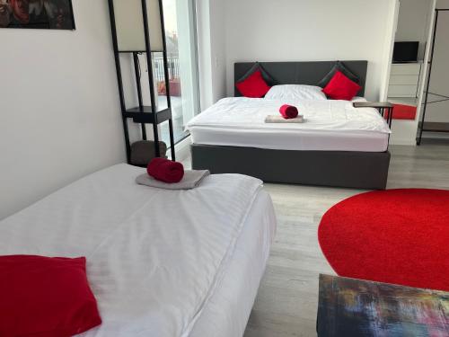 two beds in a room with red pillows on them at Weißes Haus in Gerasdorf bei Wien