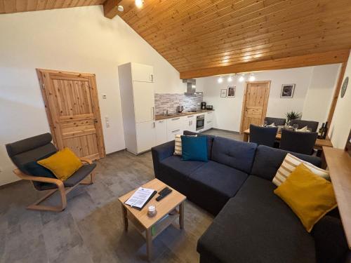 a living room with a blue couch and a table at Ferienwohnung Reifferscheid - Eifel in Hellenthal