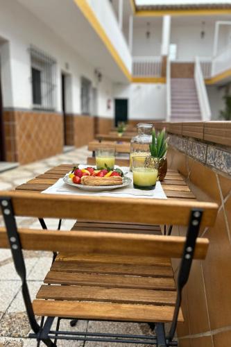 a long wooden table with a plate of food on it at Hostal Los Mellizos in Conil de la Frontera