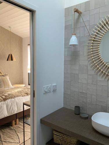 une salle de bain avec un lavabo et un miroir dans l'établissement Les Villas du Bois, au Bois-Plage-en-Ré