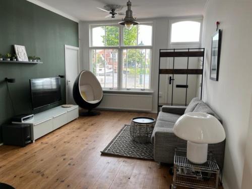 a living room with a couch and a television at Appartement aan het water in Alkmaar
