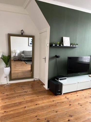 a living room with a mirror and a television at Appartement aan het water in Alkmaar