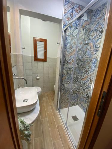 a bathroom with a glass shower and a sink at Tower Pisa apartment in Pisa