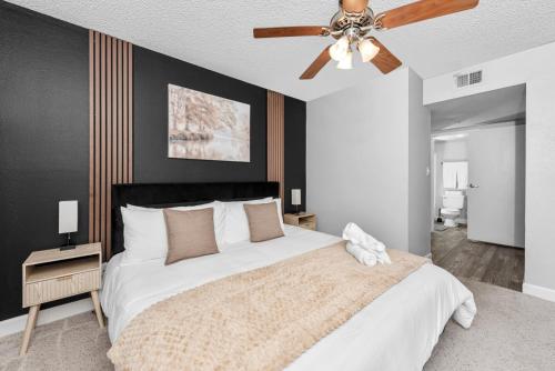 a bedroom with a large bed with a ceiling fan at Tempe Hideaway Luxe Amenities Parking in Tempe