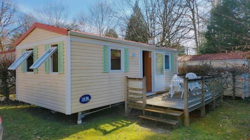 a tiny house with a porch on a yard at Mobile home in Saint-Gérons