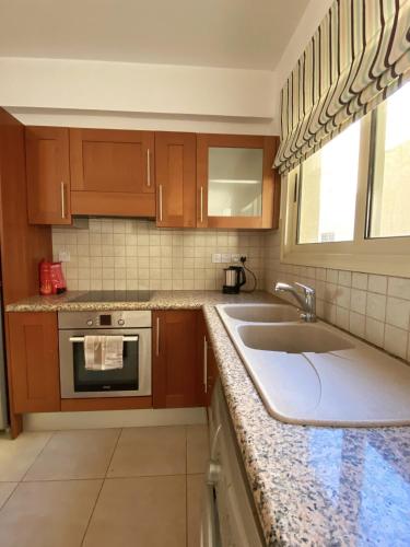 a kitchen with wooden cabinets and a sink at STAY Meadow Vista Apartment in Mandria
