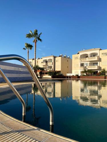 a pool of water with buildings and palm trees at STAY Meadow Vista Apartment in Mandria