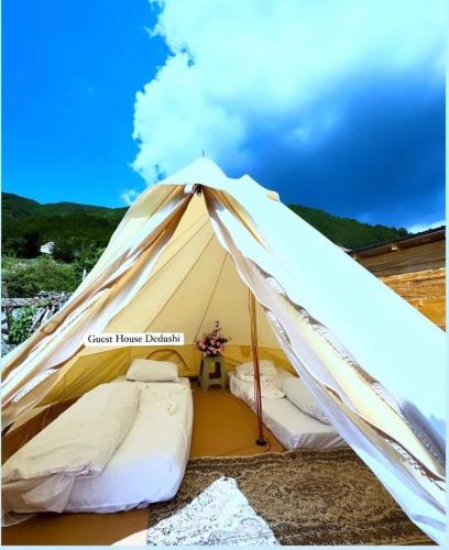 a white tent with two beds in it at Dedushi camping place in Vusanje
