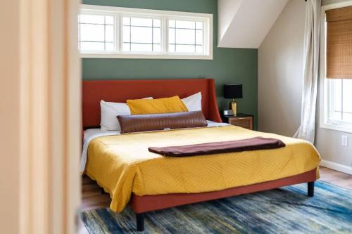 a bedroom with a bed with a red headboard and yellow pillows at Wintergreen Ridge Retreat - Family Home in Wintergreen
