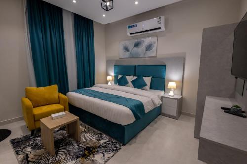 a bedroom with a blue bed and a yellow chair at شقق فندقية للضيافة - تتم ادارته من قبل مضيف مستقل - Hotel apartments for private hospitality in Jeddah