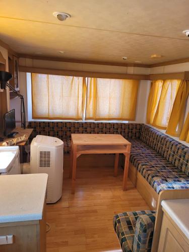 a living room with a couch and a table at Sítio da Cornucópia Home Mobile in Moncarapacho