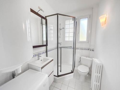 une salle de bain blanche avec douche et toilettes dans l'établissement L'Ecrin de la Jolie, à Mantes-la-Jolie